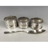 A silver butter knife and three silver napkin rings