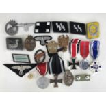 A quantity of reproduction German Third Reich insignia etc
