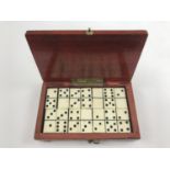 An early 20th century cased set of miniature dominoes