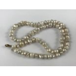 A single-strand necklace of cultured fresh-water baroque pearls, having a yellow-metal clasp, marked