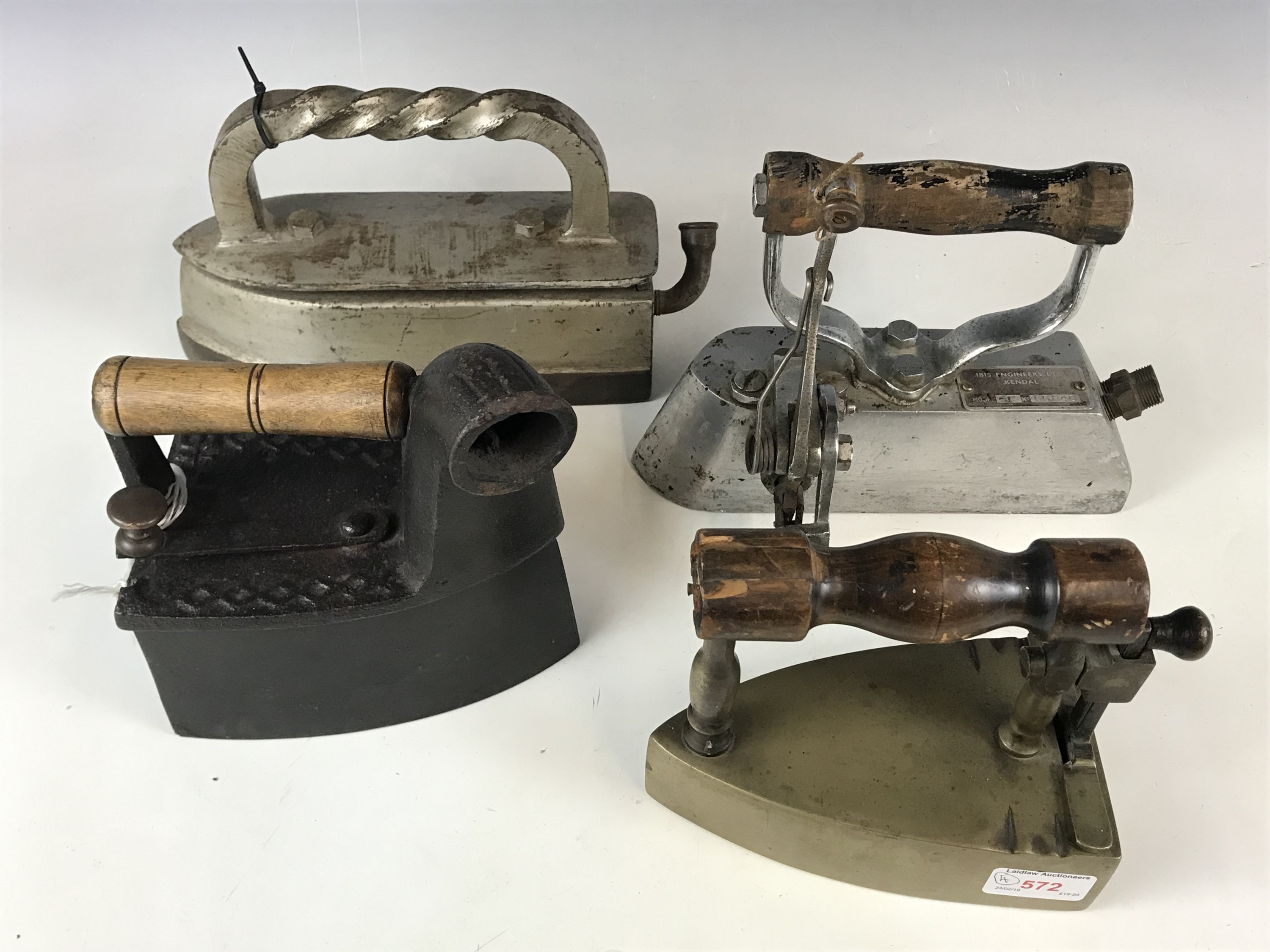 A vintage charcoal iron together with three others