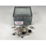 A glass bijouterie box containing a quantity of white-metal pendant earrings, to include a pair of