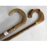 Two walking stick / crooks with carved horn terminals, one carved depicting a hound and fox