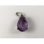 A pear-shaped amethyst pendant, the faceted gemstone being held in a contemporary crown setting,
