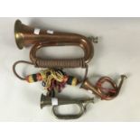 A reproduction copper bugle together with a miniature bugle and horn