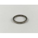 An antique precious white-metal and diamond eternity ring, the slender band being engraved and