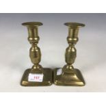 A pair of early 19th century brass push-eject candlesticks