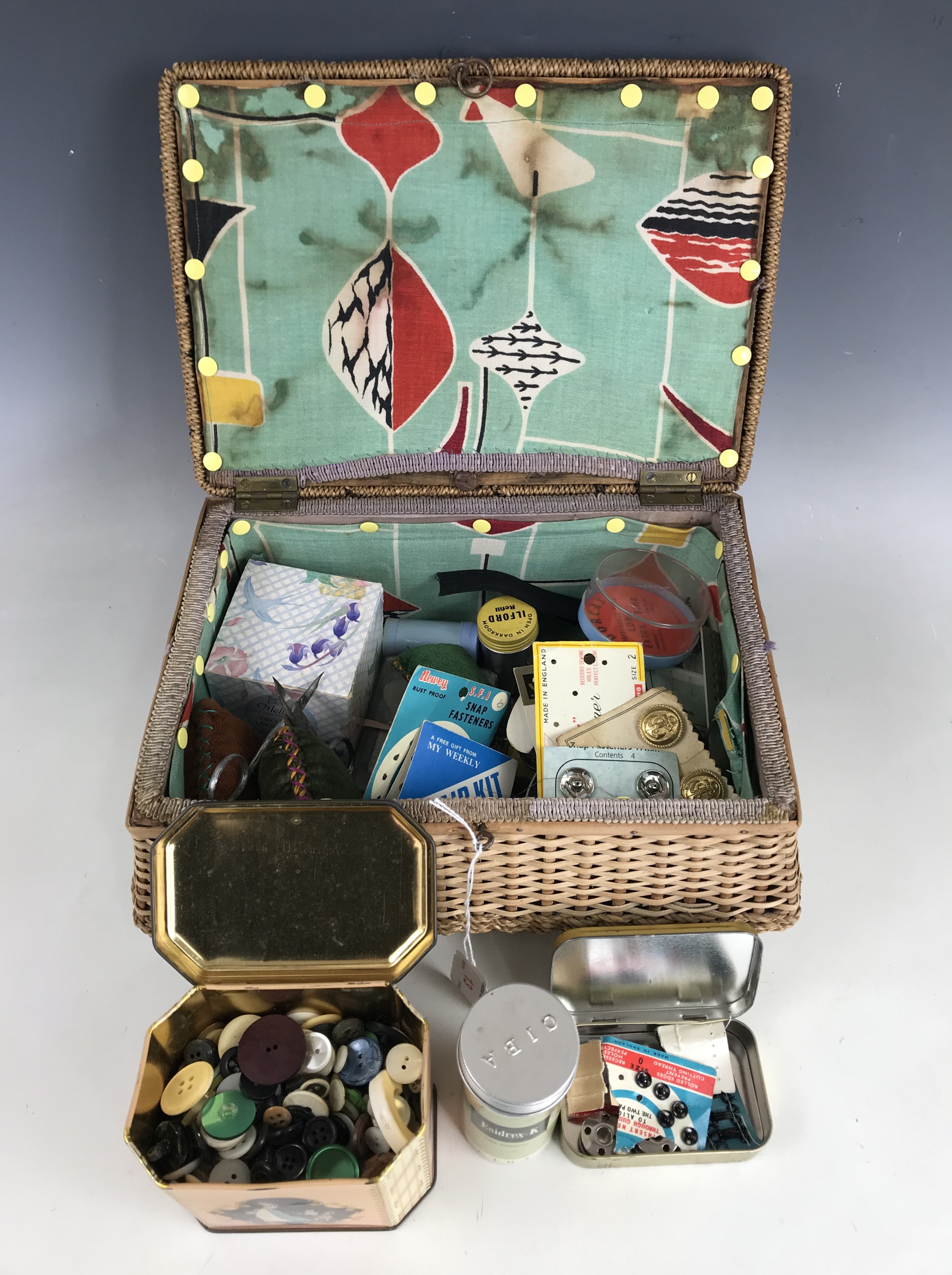 A 1950s rattan sewing casket and contents, comprising assorted sewing equipment and supplies