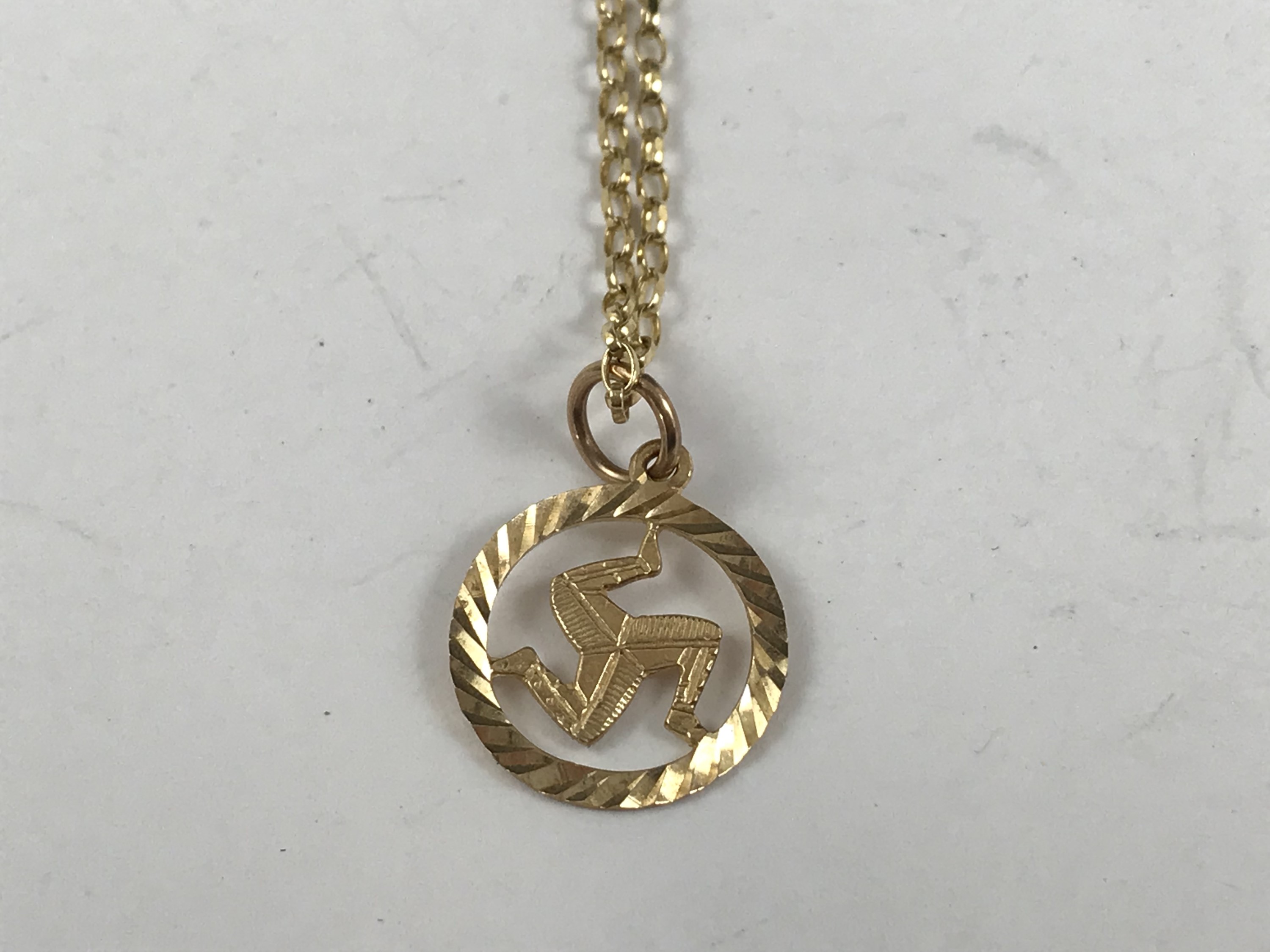 A yellow-metal Isle of Man pendant on a 9ct gold neck chain, 2.7g