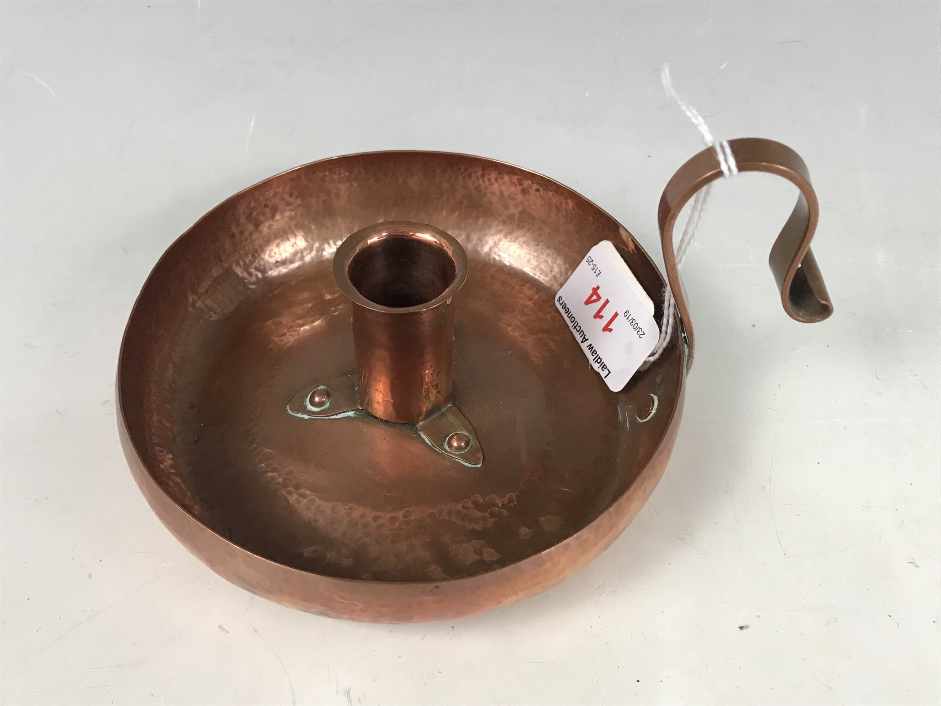 An Arts and Crafts planished copper chamber stick