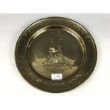A 19th Century engraved brass alms-type dish, bearing a repousse-worked armorial crest in the form