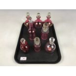 Eight cranberry glass perfume bottles