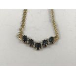 A diamond, sapphire and 9ct gold necklace, in a fixed chevron arrangement, comprising oval-cut