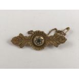 A Victorian 9ct gold Etruscan Revival bar brooch, having a central domed boss, gypsy-set with a