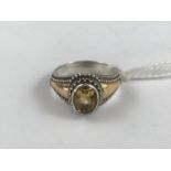 A citrine dress ring in white and yellow metal, modelled after the antique, the oval-cut and faceted