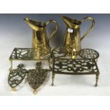 Two brass measuring jugs, and with six brass trivets