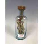 A 19th century miner's / folk art cross in glass bottle