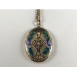A late Victorian parcel-gilt white metal locket, having engraved and champlevé enamelled