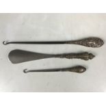 Three silver-handled button hooks