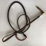 A late 19th century silver-mounted and horn-handled leather riding whip, with engraved monogram to