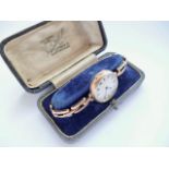 An early George V lady's 9ct rose-gold wristlet watch, having a white-enamelled face and Roman