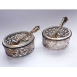 A pair of Edwardian white-metal salt cellars, of oval section, with stylized and reticulated palmate