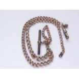 A rose yellow-metal double 'Albert' watch chain, of graded curb links, with rolled-gold T-bar and