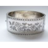 A Victorian Aesthetic Movement silver hinged-bangle, the face engraved with a floral sprig, and