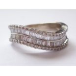 A contemporary 18ct white gold and diamond half-hoop eternity ring, the broad undulating face