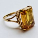 A 9ct gold and citrine cocktail ring, the emerald cut stone held above a lattice-work gallery, on