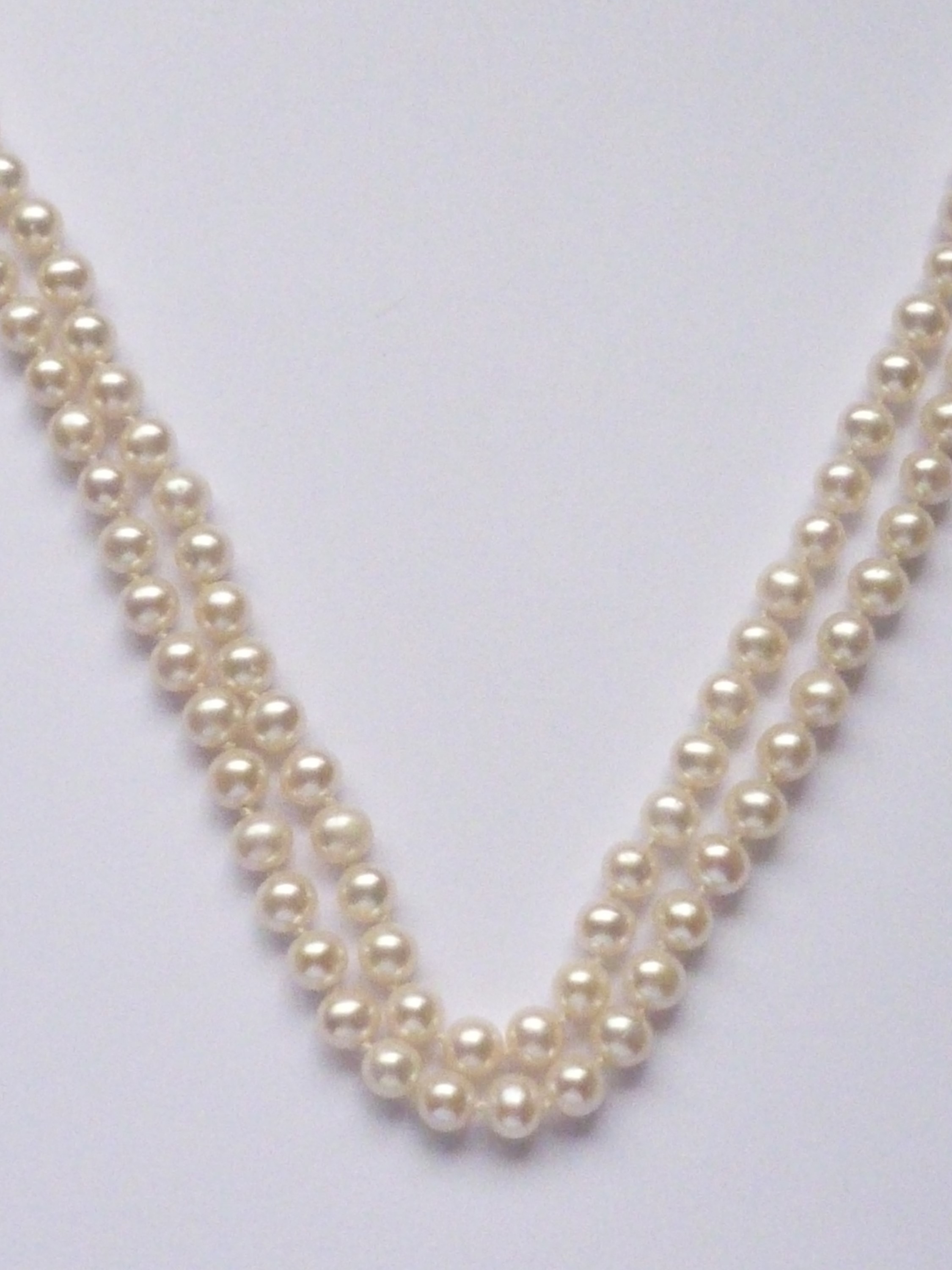 A two-strand necklace of cultured freshwater pearls, of uniform size, falling in a tiered