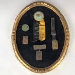 A framed display of early 20th Century aviation badges, circa 1910-1912, including a Prospect Park