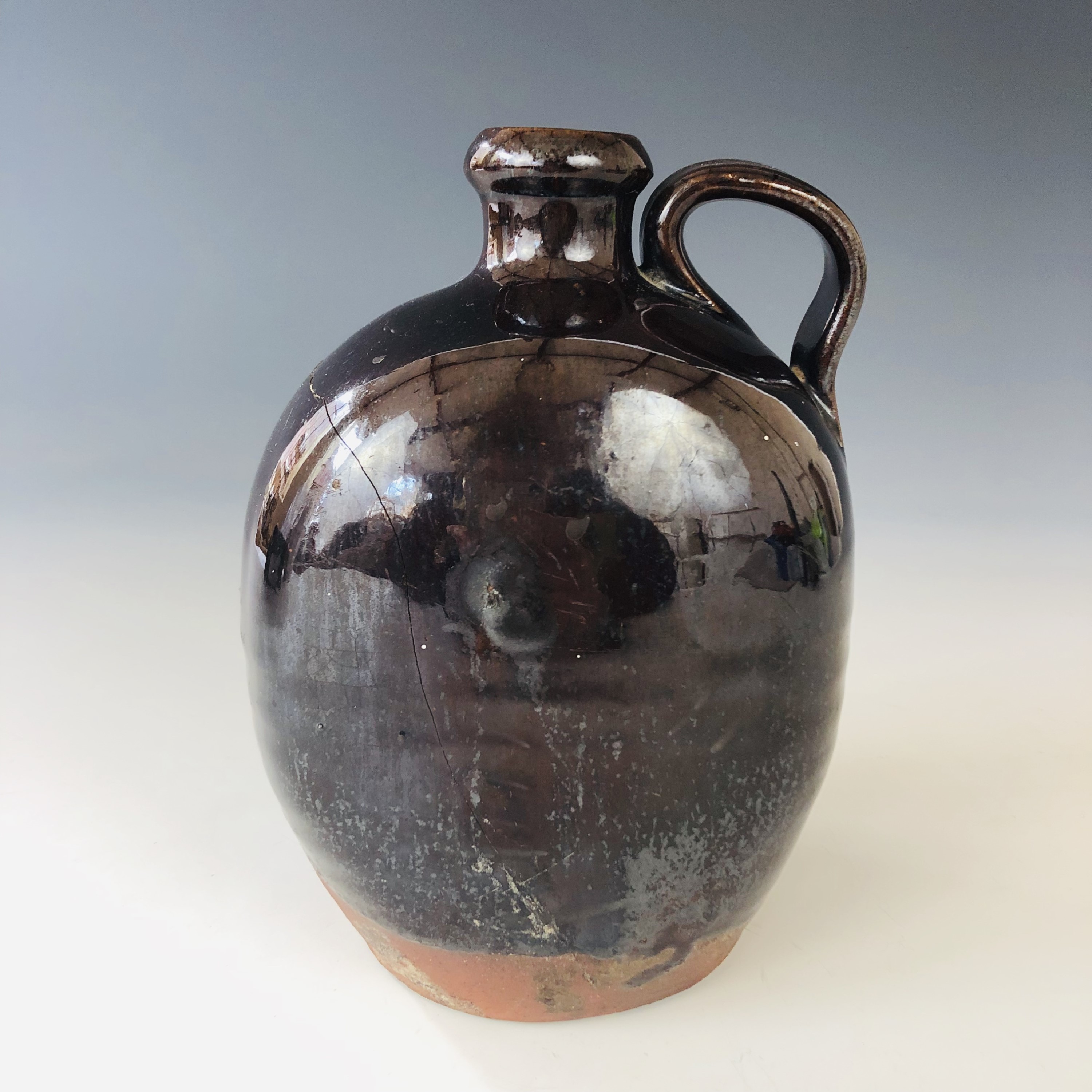 A 17th century treacle glazed stoneware flagon believed to be a witches bottle, discovered at Lawson