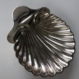 A Victorian silver butter dish in the form of a scallop shell, raised over three ball feet, Josiah