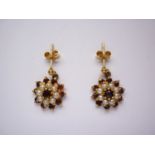 A vintage pair of garnet and pearl ear pendants, in a flower head cluster arrangement, on yellow-