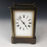 An early 20th century French brass cased carriage clock, having a Corniche case with engraved