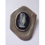 A vintage white metal and glass cameo brooch, depicting a classical figure embracing a bust on a