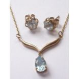 A 9ct gold and aquamarine pendant necklace and stud earring set, the necklace having a pear-shaped