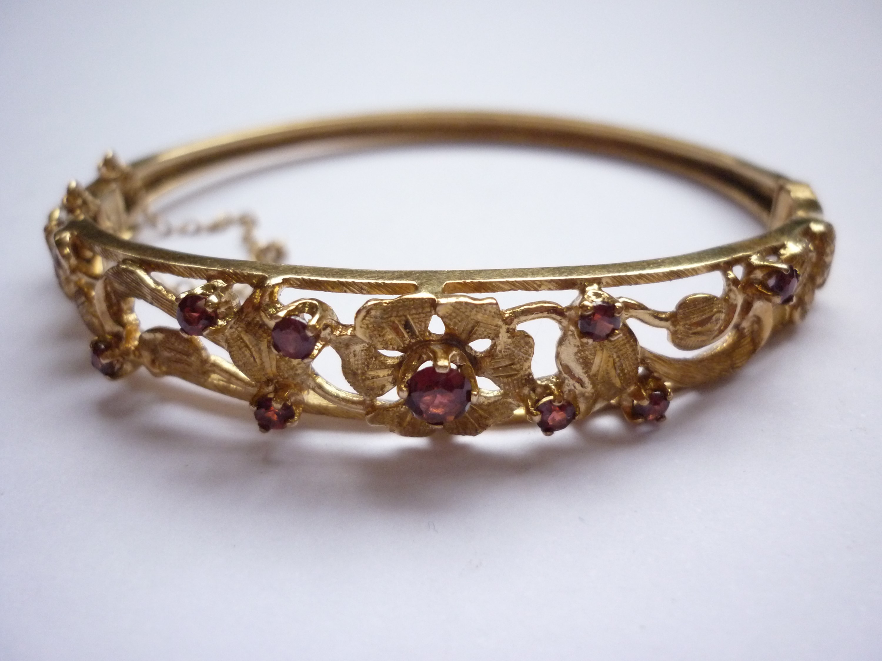 A 9ct gold and garnet hinged bangle