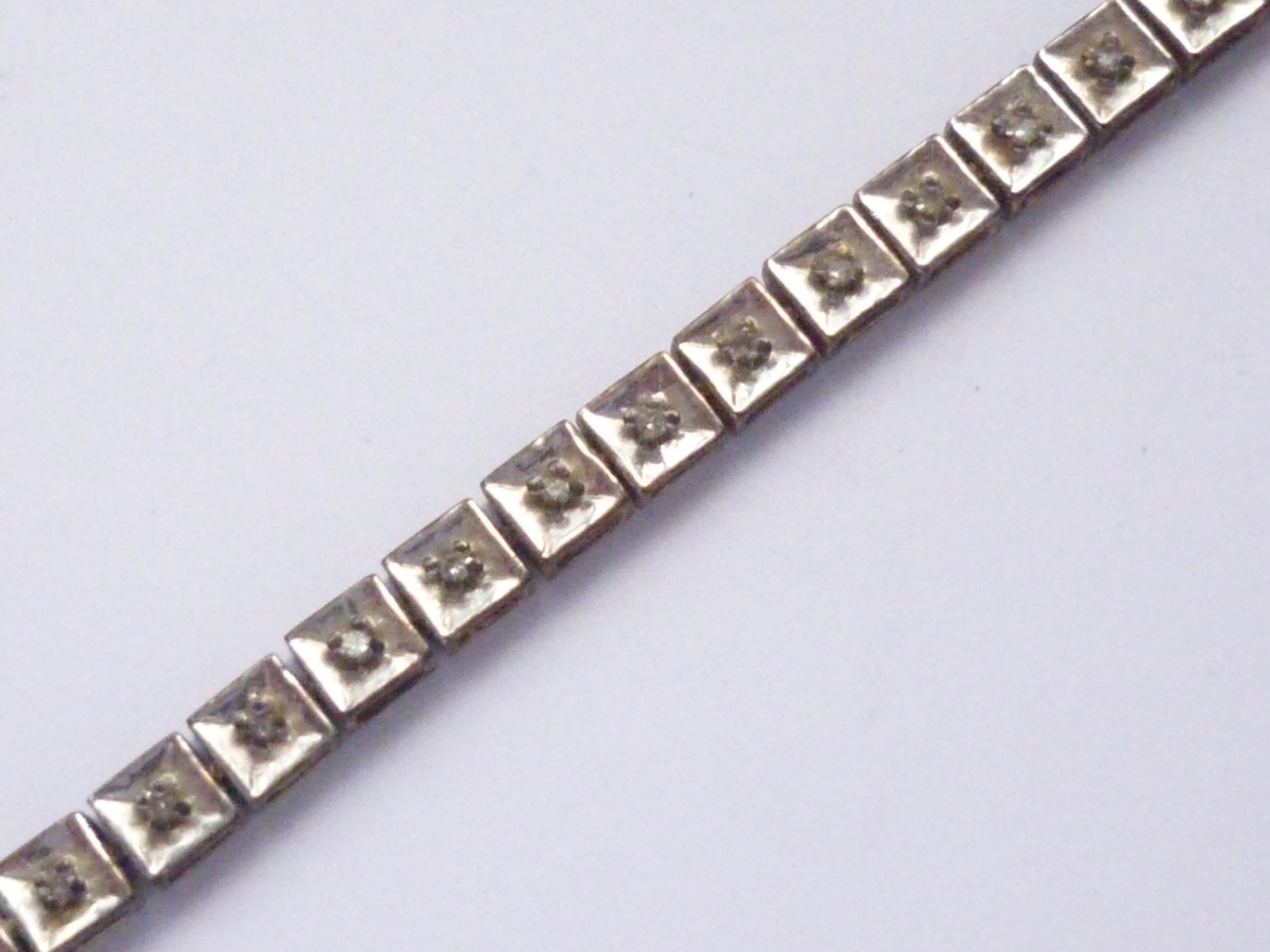 A vintage 9ct gold and diamond 'tennis' bracelet, having square-section links, the face of each