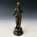A late 19th / early 20th century bronzed statuette of a Dutch fisherman holding pipe and basket,