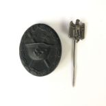 A German Third Reich black wound badge, numbered 65 verso, together with a Wehrmacht stick pin
