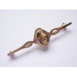 A 9ct gold and citrine bar brooch, the central oval-cut citrine of approximately 2.4ct bezel set