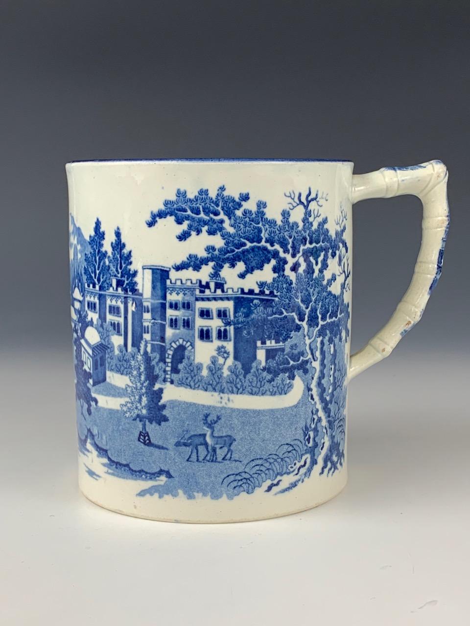 An early 19th century blue and white transfer-printed pearlware tankard, depicting an oriental