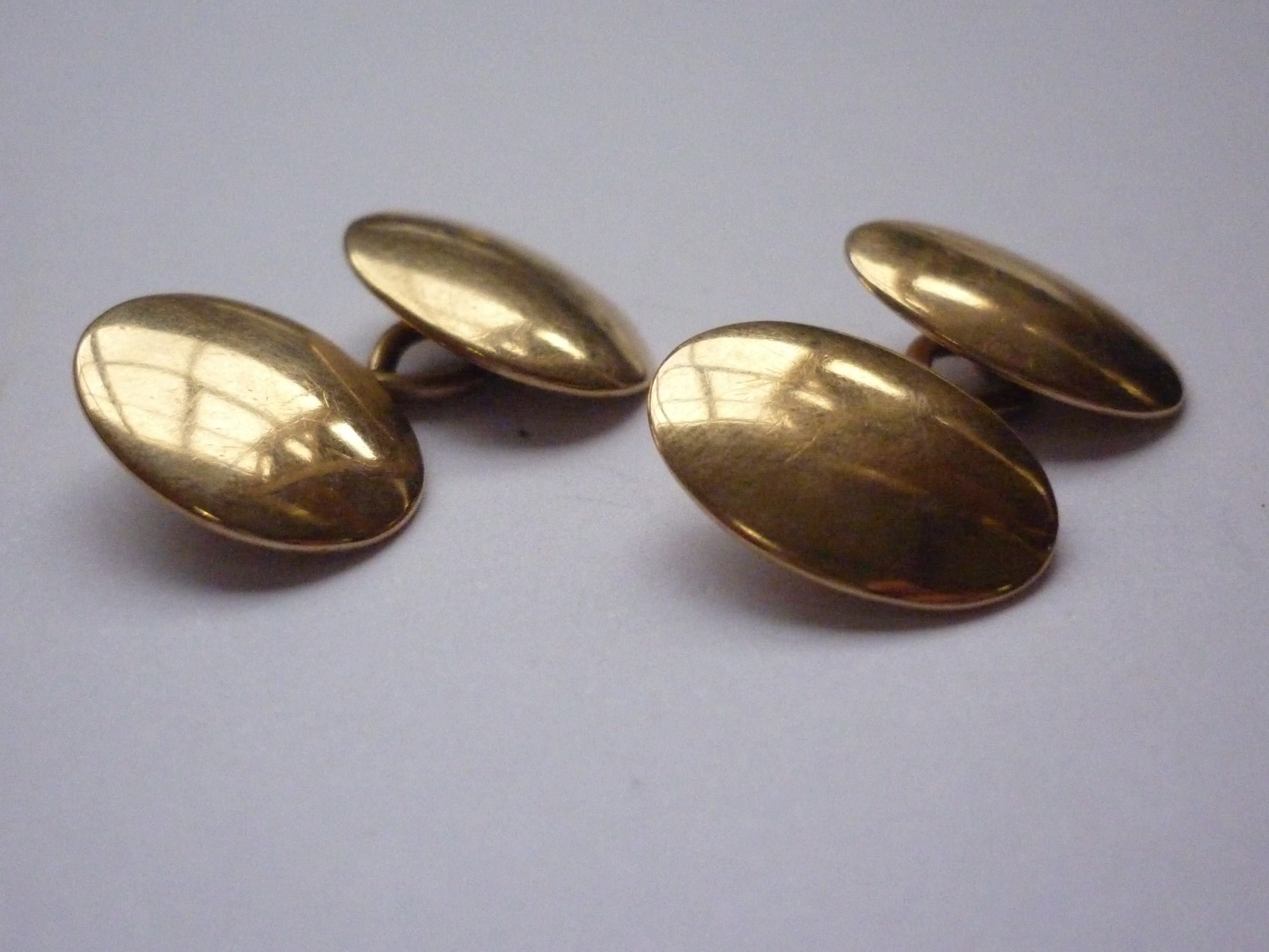 A pair of high-carat yellow metal cuff links, of convex oval form, test as gold, 9.7g