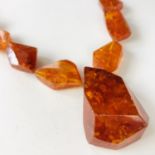A 1930s Art Deco amber bead necklace, largest bead 5.5 cm, necklace approx 66 cm long, 75 g