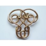 An Edwardian yellow-metal openwork scroll brooch, 11.1g