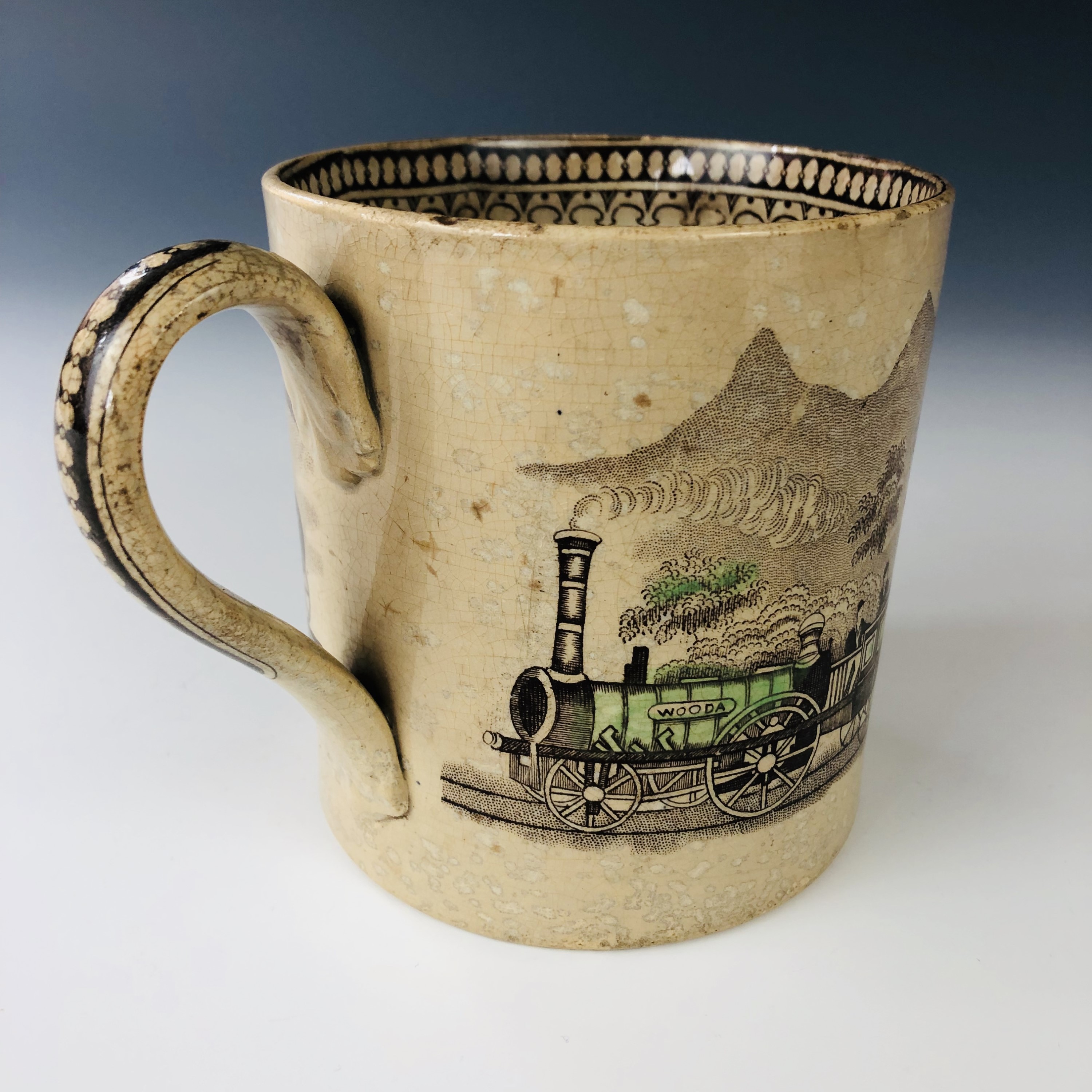 A mid 19th century Staffordshire pottery railway pattern mug, decorated in the round with a