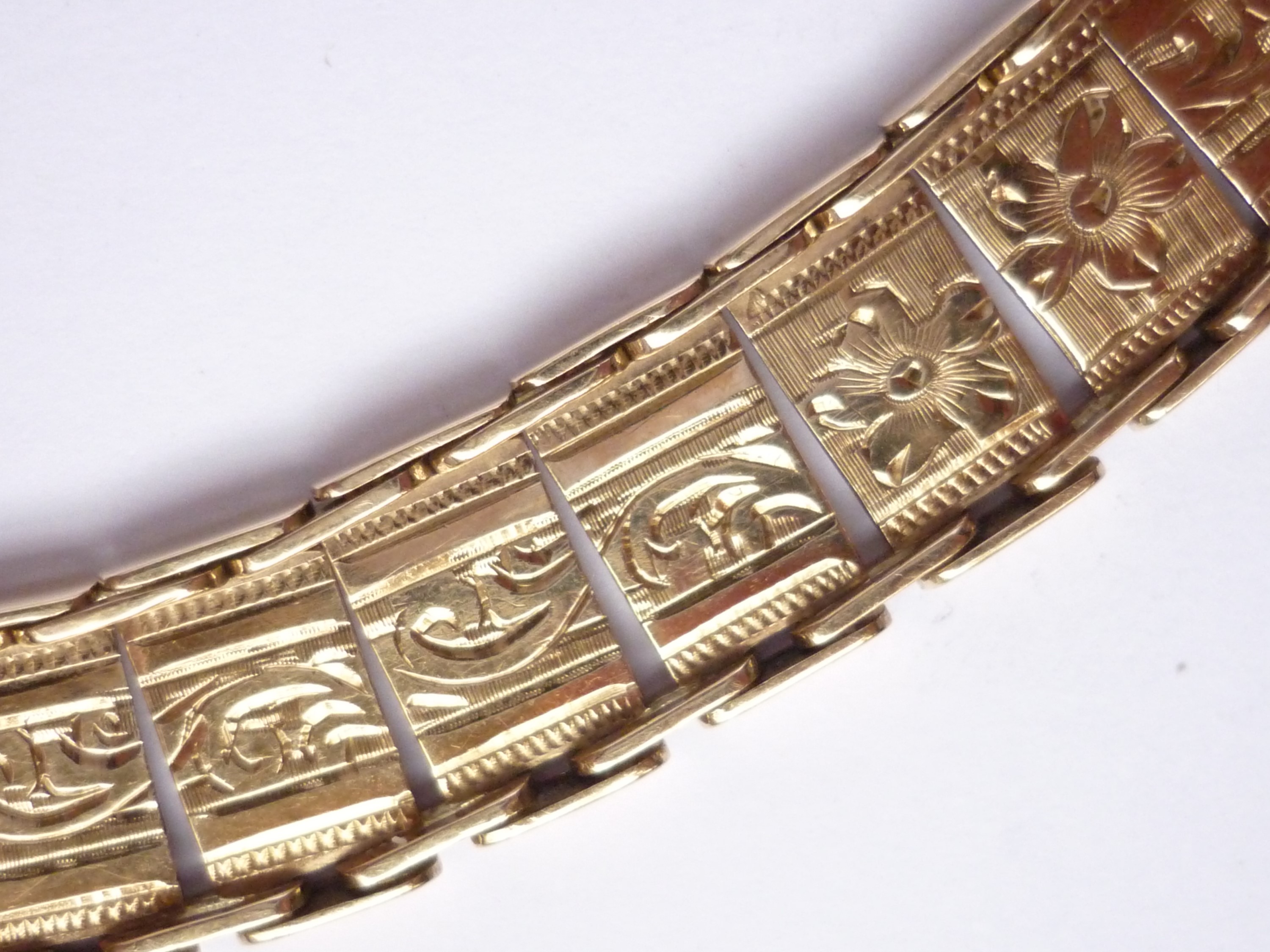 A 9ct gold articulated bracelet, having rectangular plaques florally engraved and bright-cut, 16g - Image 2 of 2