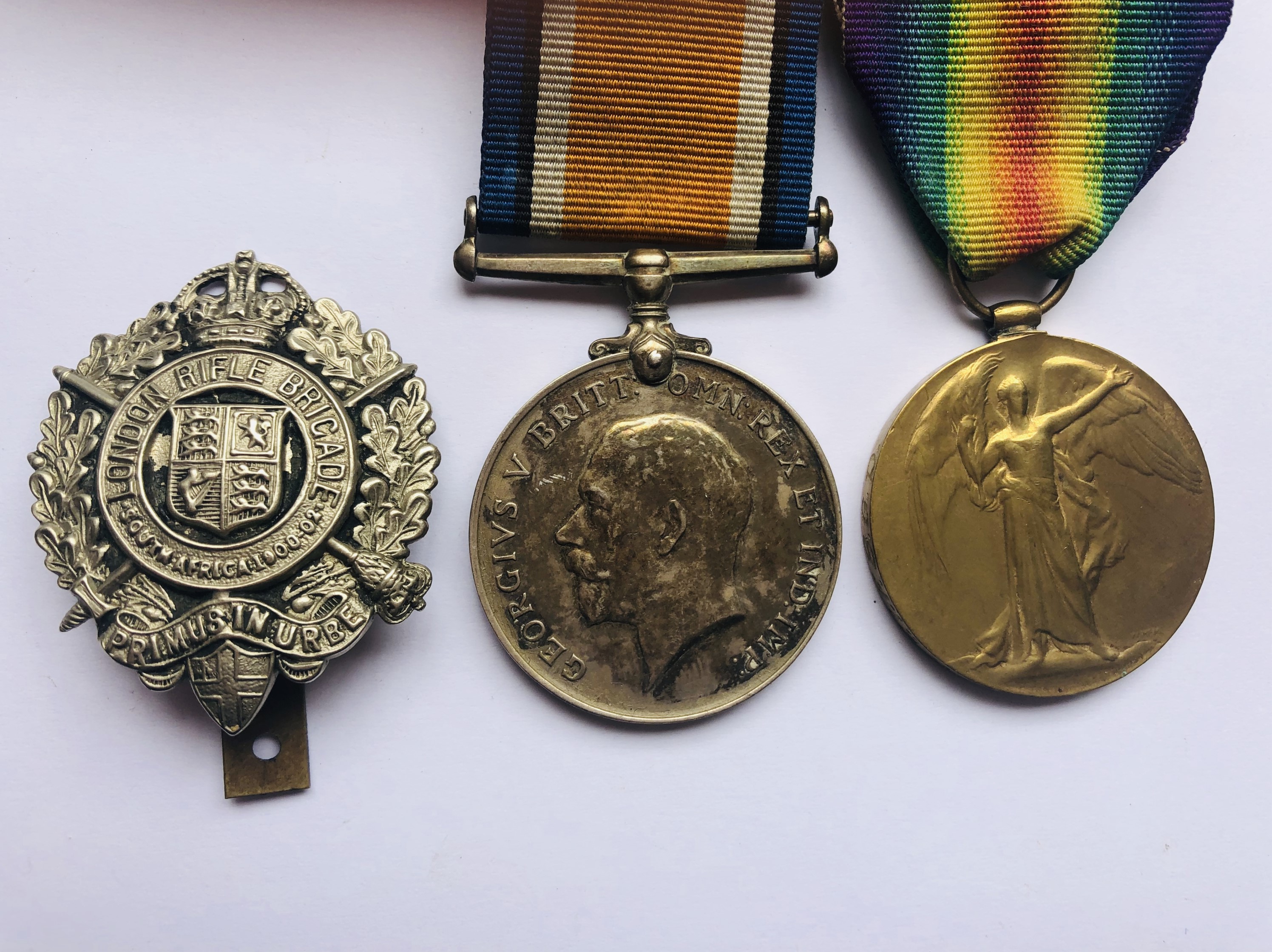 British War and Victory Medals [engraved] to 97693 Rflm C E Austin Rfl Bgd, with cap badge